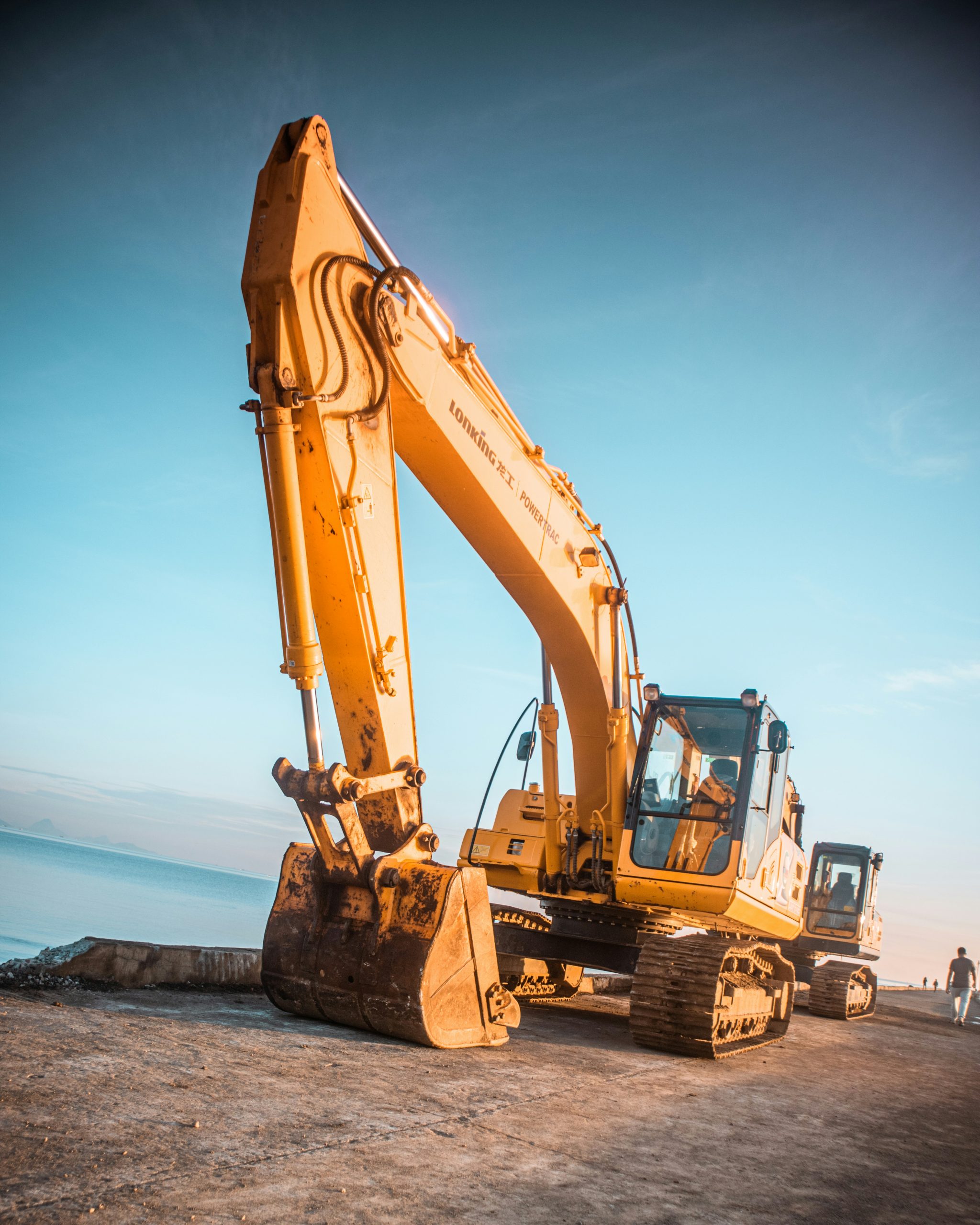 Professional orange excavator on construction site - expert NPORS, CPCS & NVQ plant machinery training and operator certification