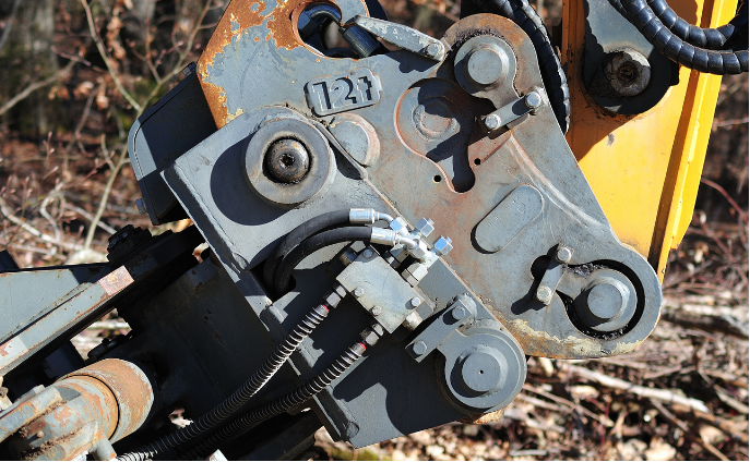 Operator inspecting excavator quick hitch attachment during NPORS N726 training