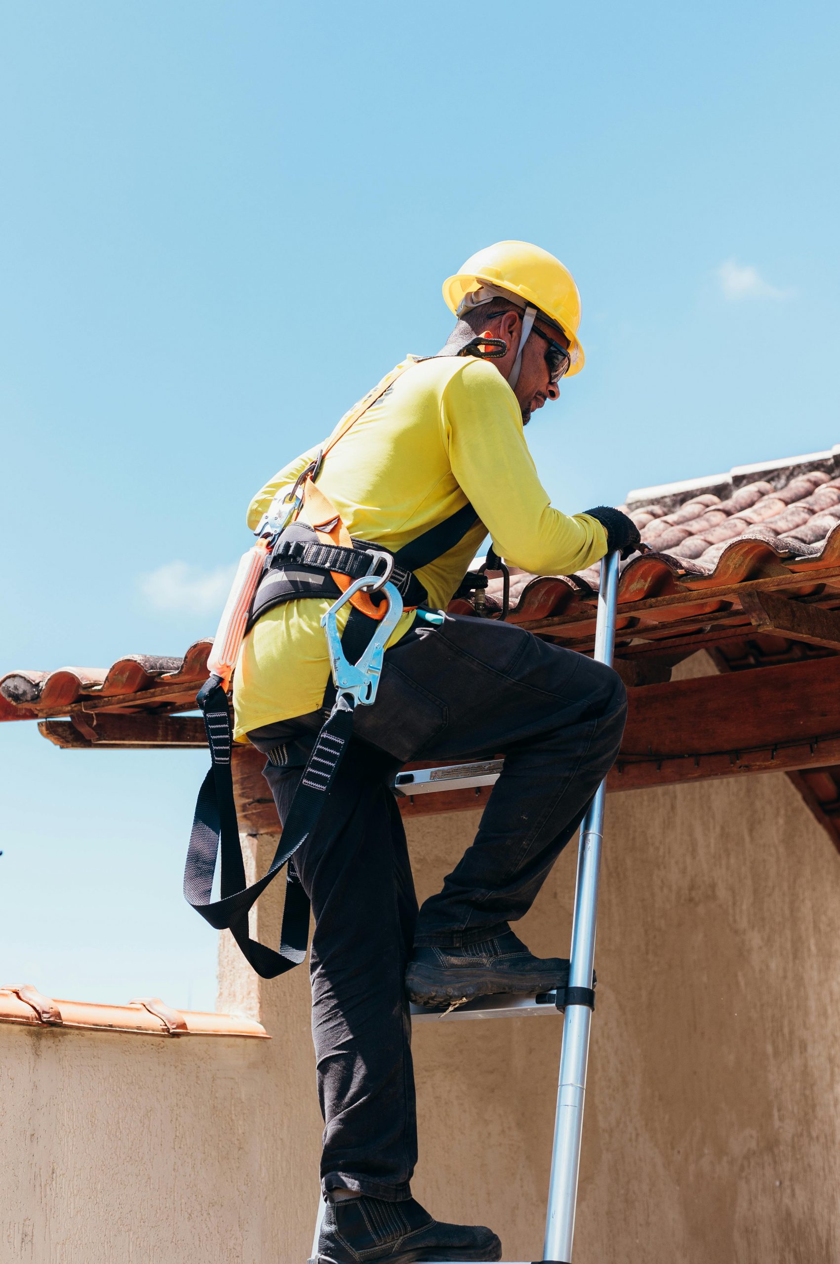 Worker wearing fall arrest harness while working on a ladder during NPORS N723 training