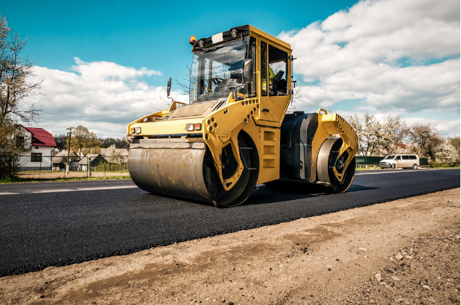 Operator driving road roller during NPORS N214 training on construction site